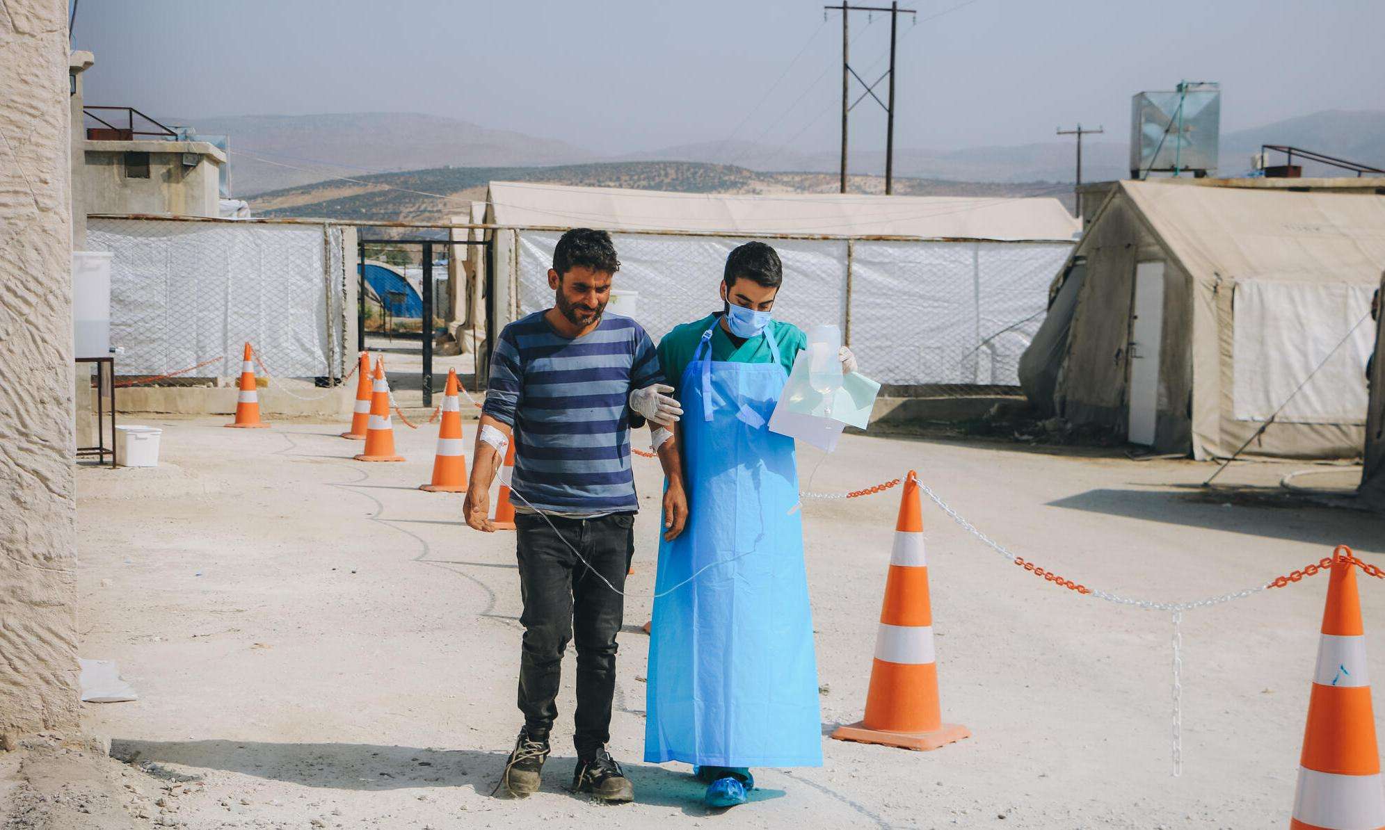 An MSF staff member escorts a cholera patient in northwest Syria.