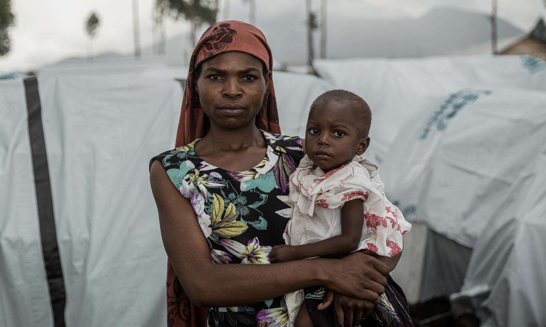 A woman holding a baby in a makeshift camp near Goma, Democratic Republic of Congo