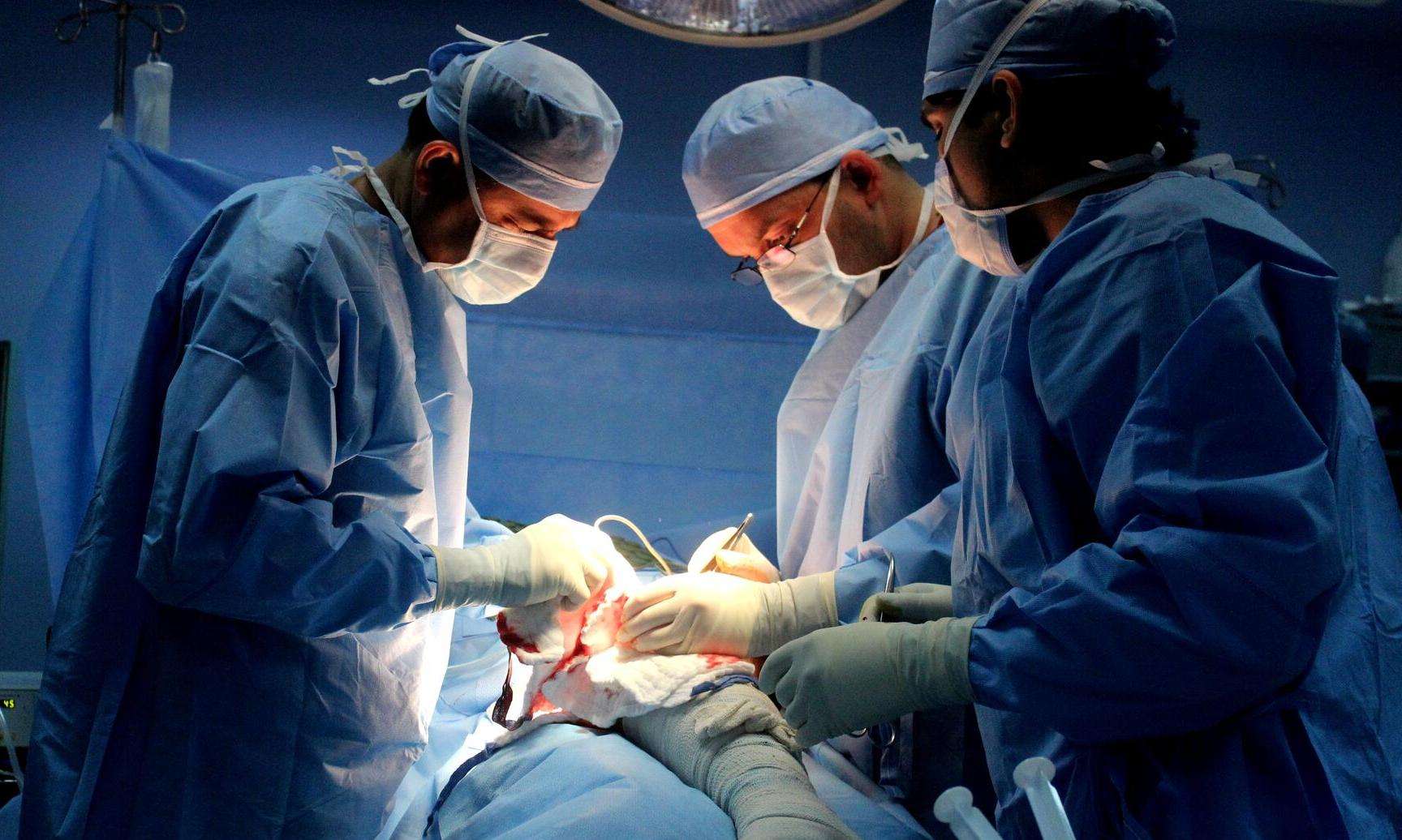 Dr. Rasheed Fakhri, an MSF surgeon, performs surgery with two colleagues in Amman, Jordan.