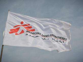 White flag of Doctors Without Borders/Médecins Sans Frontières (MSF) against the sky