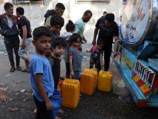 Palestinian children line up for water during Israel-Gaza war of 2023.