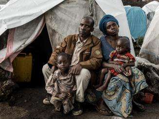 A displaced family in front of their tent in Democratic Republic of Congo