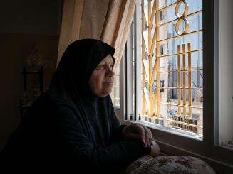 A Palestinian woman looks out from her window in Hebron, occupied West Bank.