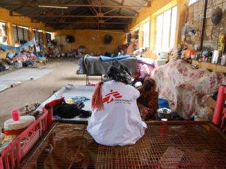 The back of an MSF staff member sitting in a room in Wad Madani, Sudan.