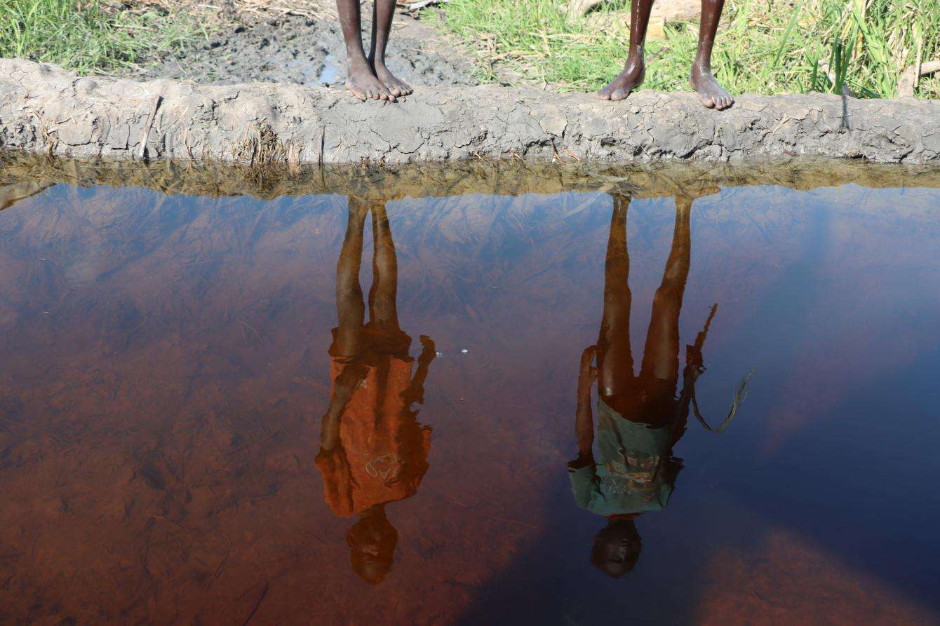 Reflection of two people on the surface of water in South Sudan