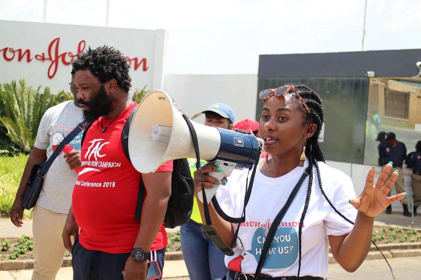 A woman who works for the MSF access campaign speaking through a bull horn and walking down the street in Midland, South Africa.