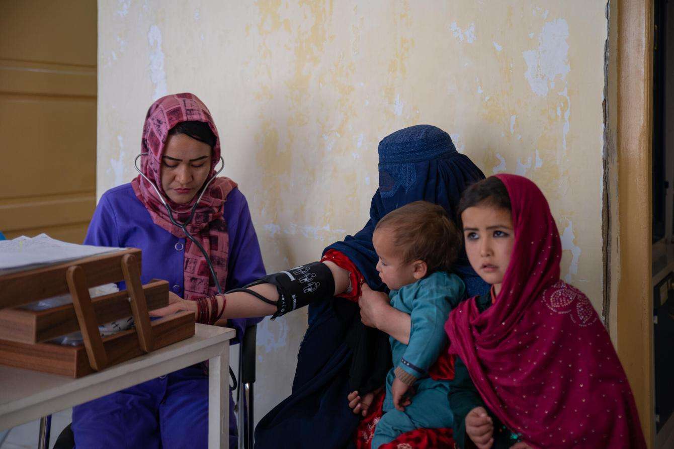 MSF staff member takes the blood pressure of a patient in an MSF-supported health facility in Afghanistan.