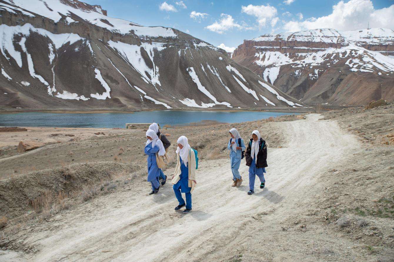 Girls walk to school with mountains of Bamyan province, Afghanistan in the background.