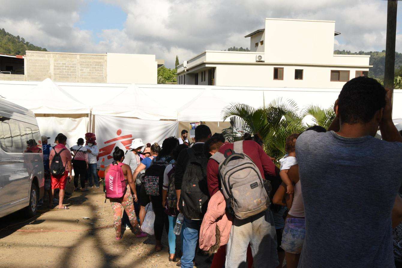 A long line of people wait to receive medical care by an MSF tent in Danlí, Honduras.