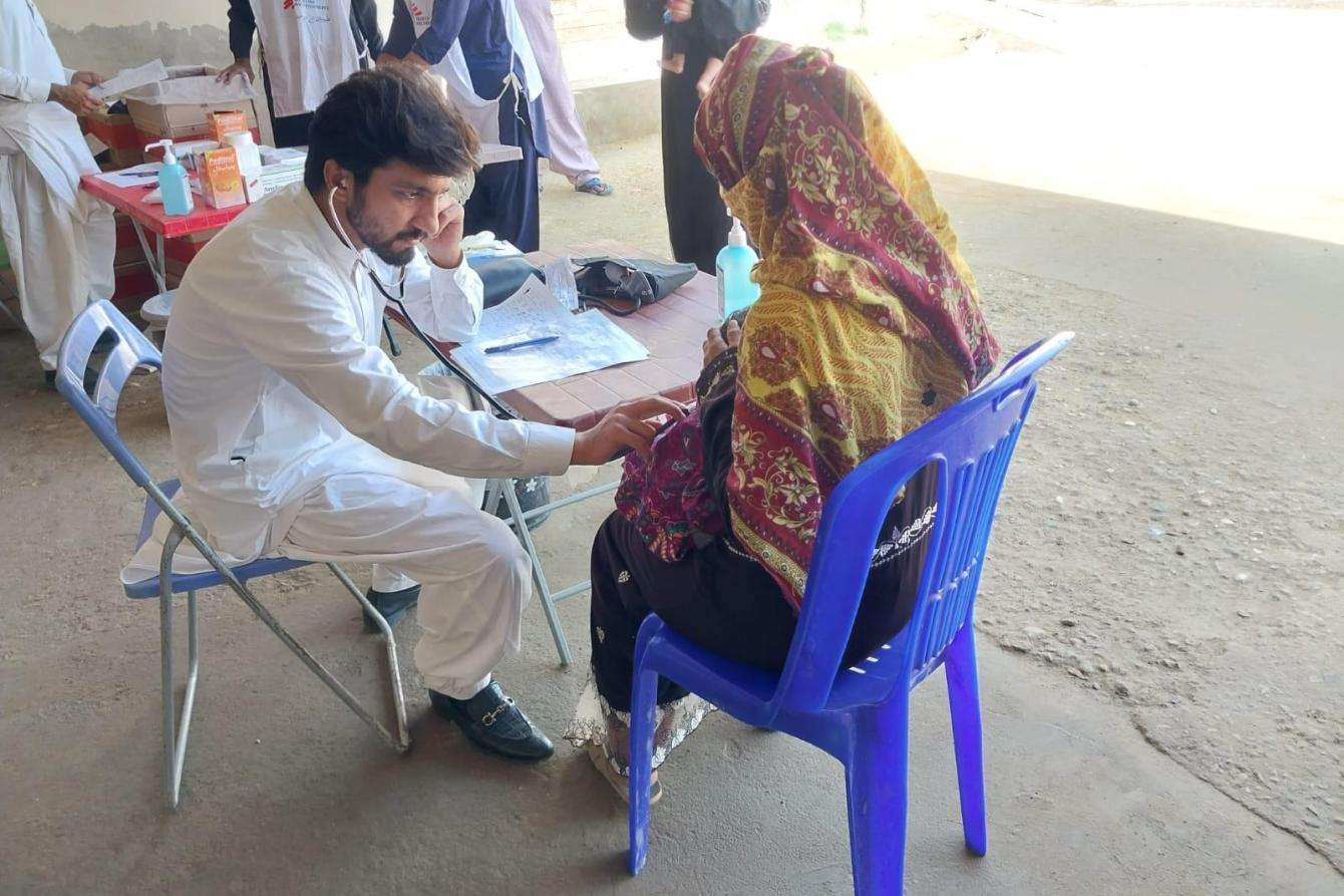 A staff member meets with a woman who brought her child to MSF's facility in Dadu for malnutrition treatment. 