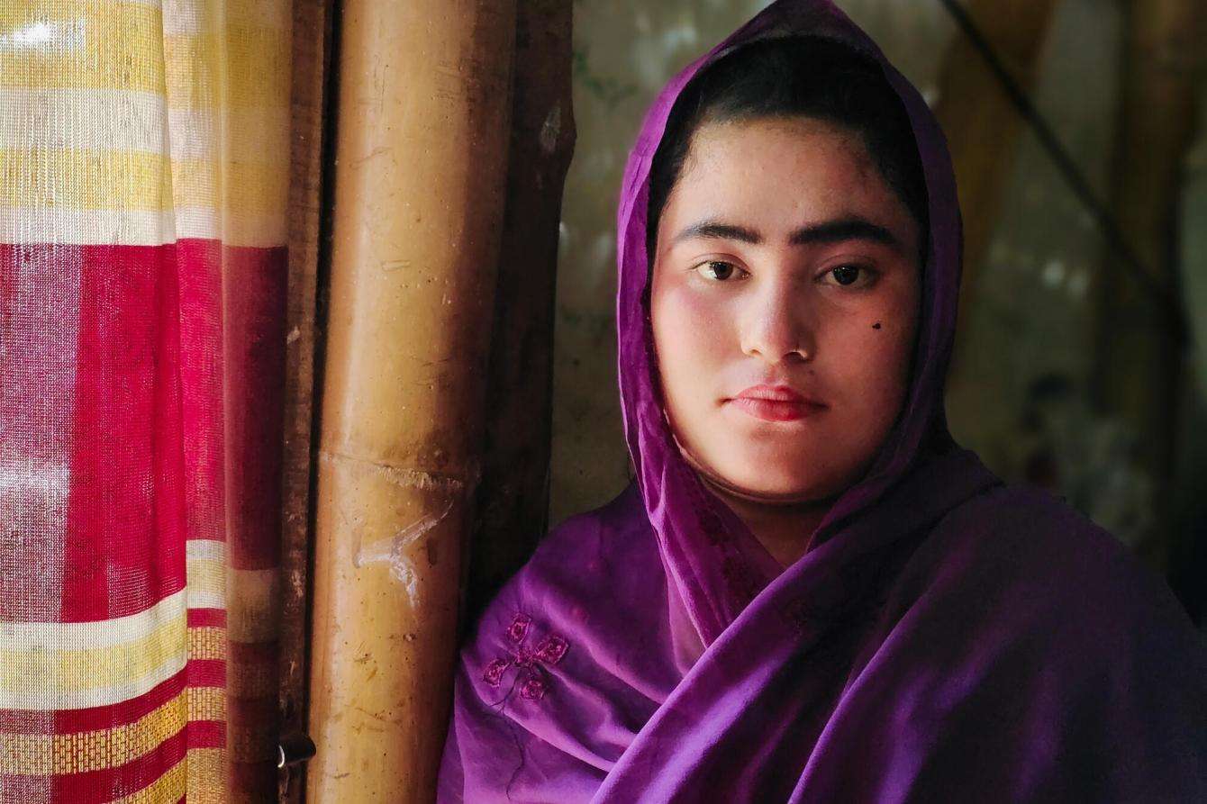 A young Rohingya woman in a purple scarf.
