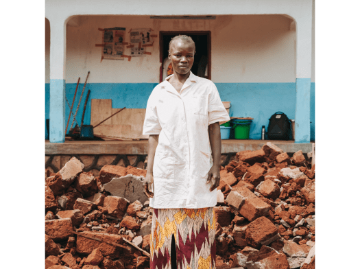 An MSF nurse standing on rubble in front of a health facility in Central African Republic