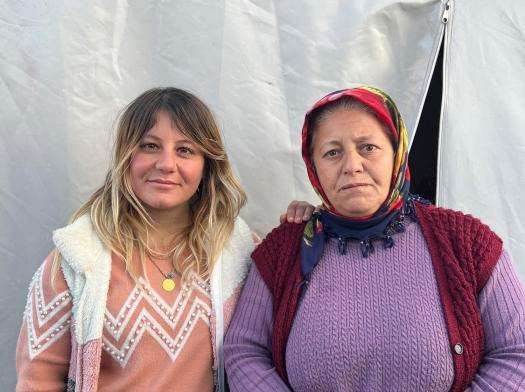 A mother and daughter beside their tent after being displaced by the earthquake in Turkey.