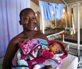 A mother smiles holding her baby in Kajo Keji, South Sudan